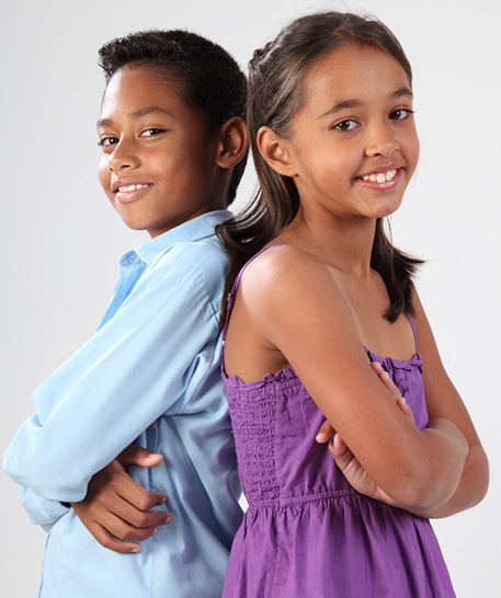 a boy and a girl standing back to back and smiling