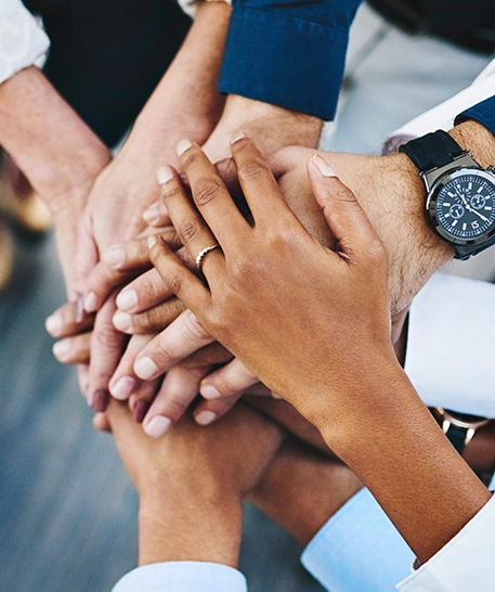 Island Orthodontics team members in a group huddle putting hands together